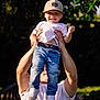 child, toddler, adult, outdoor, nature, greenery, cap, jeans, white_shirt, smile, happy, sunlight, holding, hands, person, play, park, tree, daylight, fun