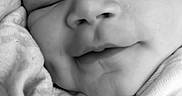 Katalayah is registered to the contest to win money with this photo: baby, sleeping, close_up, black_and_white, infant, face, peaceful, soft_texture, newborn, portrait, child, cute, resting, smile, skin, clothing, tiny, arm, head, young