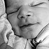 baby, sleeping, close_up, black_and_white, infant, face, peaceful, soft_texture, newborn, portrait, child, cute, resting, smile, skin, clothing, tiny, arm, head, young
