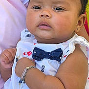 Zia Le'Ashia is registered to the contest to win money with this photo: baby, child, infant, person, outdoor, greenery, clothing, white_dress, bow, bracelet, earring, hand, arm, adult_hand, portrait, cute, serious_expression, holding, skin, head