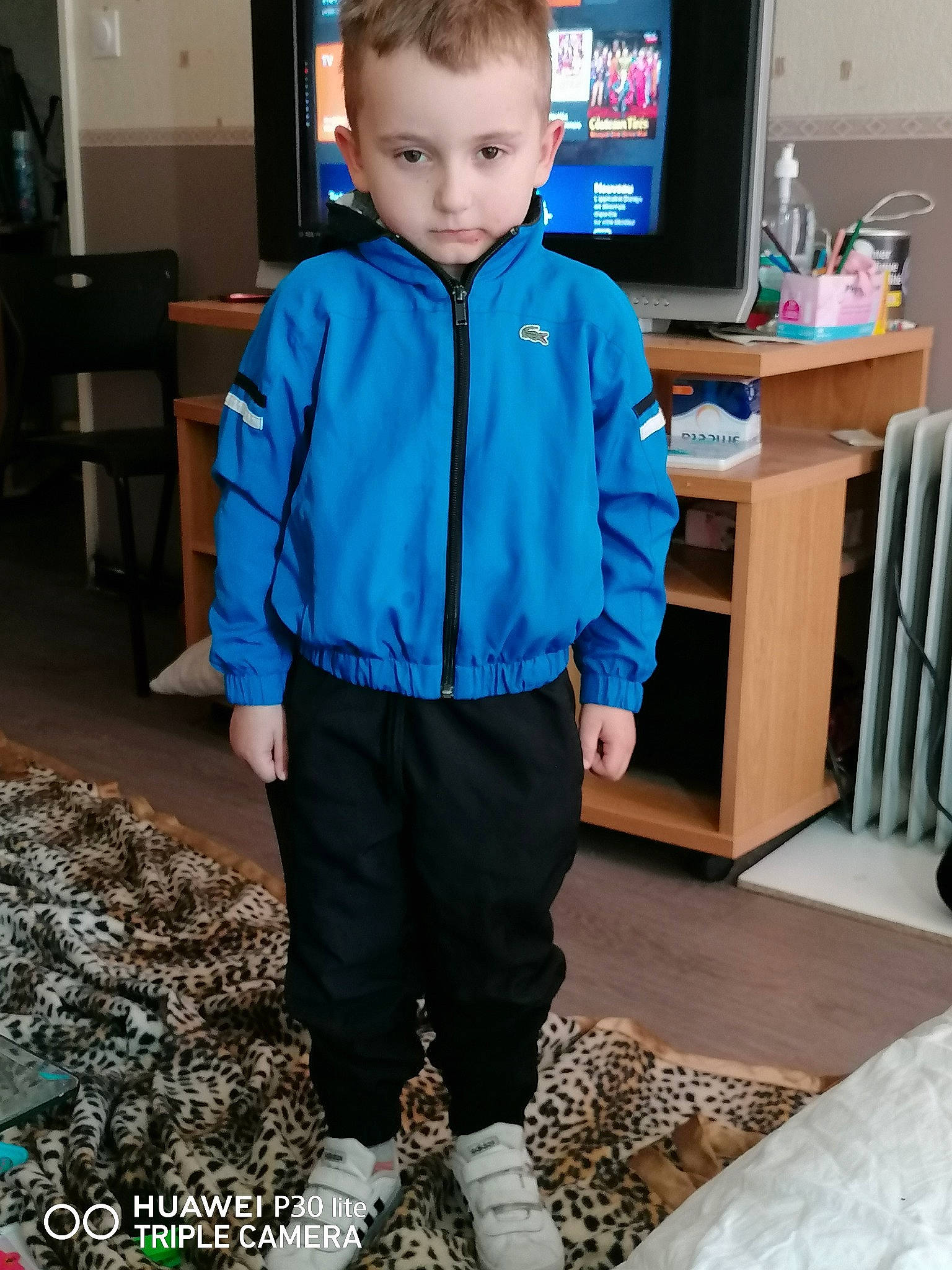 Jessy participe au concours pour gagner de l'argent avec cette photo : black, blue, chair, electric_blue, flooring, formal_wear, fun, joint, knee, person, personal_protective_equipment, room, shelf, shoe, sleeve, sportswear, standing, sweatpant, t_shirt, television