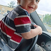 Jeff joined the competition — help win amazing prizes! child, toddler, boy, steering_wheel, car_interior, striped_shirt, blue_eyes, smiling, playful, vehicle, dashboard, window, daylight, casual_clothing, young_child, portrait, indoor, seat, hand, happy