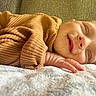 Connor is registered to the contest to win money with this photo: baby, sleeping, smiling, face, hand, blanket, sweater, ribbed_clothing, cozy, resting, infant, closeup, portrait, peaceful, indoors, couch, soft_texture, warm_colors, child, cute