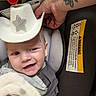 Connor joined the competition — help win amazing prizes! baby, blanket, car_seat, child, clothing, comfort, cowboy_hat, cute, face, hand, happy, headwear, indoor, infant, person, playful, seat, smile, tattoo, toy