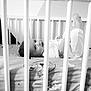 Ismaël participe au concours pour gagner de l'argent avec cette photo : baby, baby_bed, bars, bed, black_and_white, child, clothing, crib, cute, happy, indoor, infancy, infant, lying_down, monochrome, person, playful, portrait, smiling, young_child