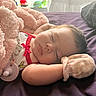 baby, sleeping, infant, bed, blanket, pink_blanket, purple_bedding, pacifier, red_bow, mitten, onesie, portrait, indoors, bedroom, resting, peaceful, face, closed_eyes, soft_toys, cozy