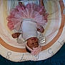 baby, infant, tutu, pink_tutu, headband, flower_headband, lying_down, colorful_mat, numbers, silver_wings, white_top, cute, child, indoors, soft_toy, play_mat, baby_girl, smiling, face, person