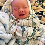 Elijah joined the competition — help win amazing prizes! baby, blanket, child, closeup, comfortable, cozy, cute, dinosaur_pattern, expression, face, happy, indoor, infant, newborn, pajamas, portrait, sleepy, smiling, soft_texture, wrapped