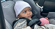 Nessa joined the competition — help win amazing prizes! baby, blanket, car_interior, car_seat, child, clothing, eyes, face, harness, hat, indoor, infant, looking_away, pink_toy, portrait, safe_travel, seatbelt, sitting, striped_hat, vehicle