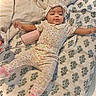 arms_outstretched, baby, bed, bedroom, bedspread, bottle, bow, child, cute, floral_pattern, headband, indoor, infant, juicy, lying_down, pajamas, pink_clothing, portrait, smiling, socks