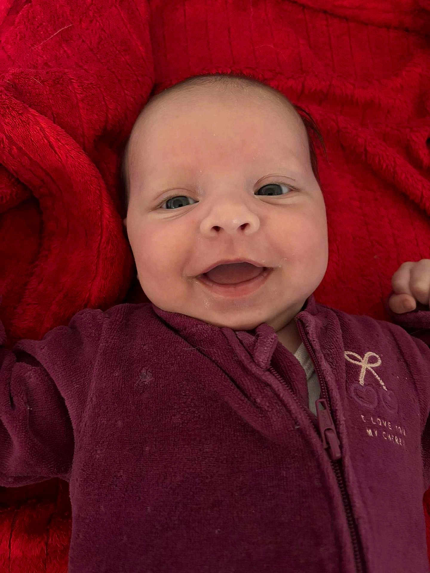 Horia a rejoint le concours — aidez-le/la à gagner de superbes lots ! baby, smiling, face, infant, closeup, red_blanket, purple_onesie, happy, child, cute, portrait, baby_clothing, zipped_jacket, indoors, soft_texture, young_child, head, skin, eyes, mouth