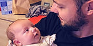 Horia a rejoint le concours — aidez-le/la à gagner de superbes lots ! baby, man, indoor, holding, onesie, floral_pattern, beard, love, heart_emoji, portrait, family, child, person, face, candid, expression, clothing, affection, interaction, cozy