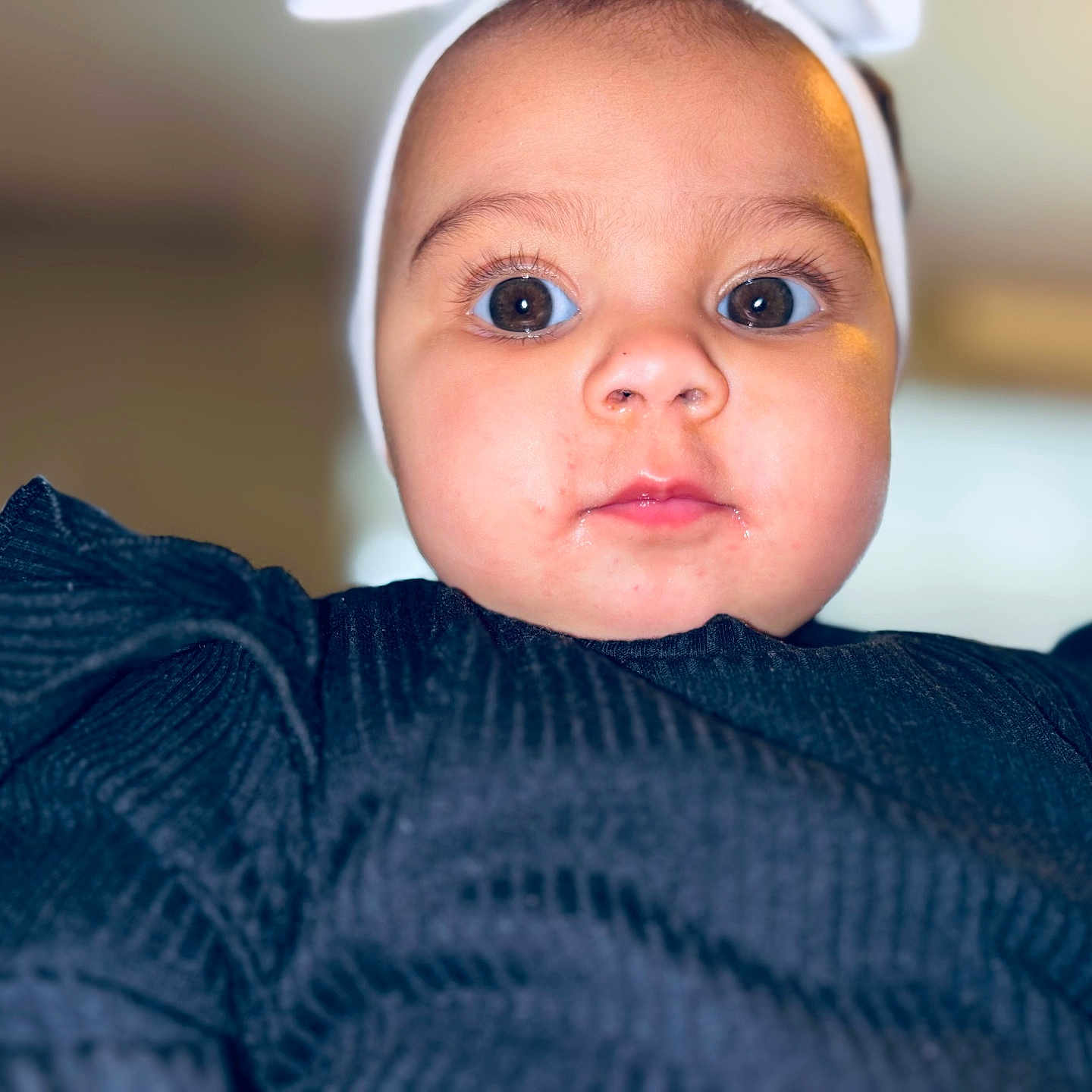 Amriah Jasmine is registered to the contest to win money with this photo: apparel, baby, black_clothing, child, closeup, curious, cute, expression, eyes, face, fashion, headband, indoor, infant, person, portrait, ruffles, skin, soft_light, young_child