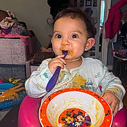 Amriah Jasmine is registered to the contest to win money with this photo: baby, bowl, chair, child, clothing, cute, face, feeding, food, hair, indoor, messy, mickey_mouse, minnie_mouse, person, plate, room, smiling, spoon, toddler