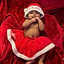 baby, infant, child, red_tutu, santa_hat, christmas, holiday, plush_blanket, cute, smiling, festive, bare_chest, hands, feet, portrait, indoors, celebration, red_color, soft_texture, happy