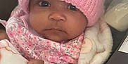 Ki'Mani is registered to the contest to win money with this photo: baby, infant, pink_hat, blanket, car_seat, floral_clothing, face, child, cozy, warm, cute, portrait, indoor, newborn, apparel, person, headwear, soft_texture, wrapped, seated