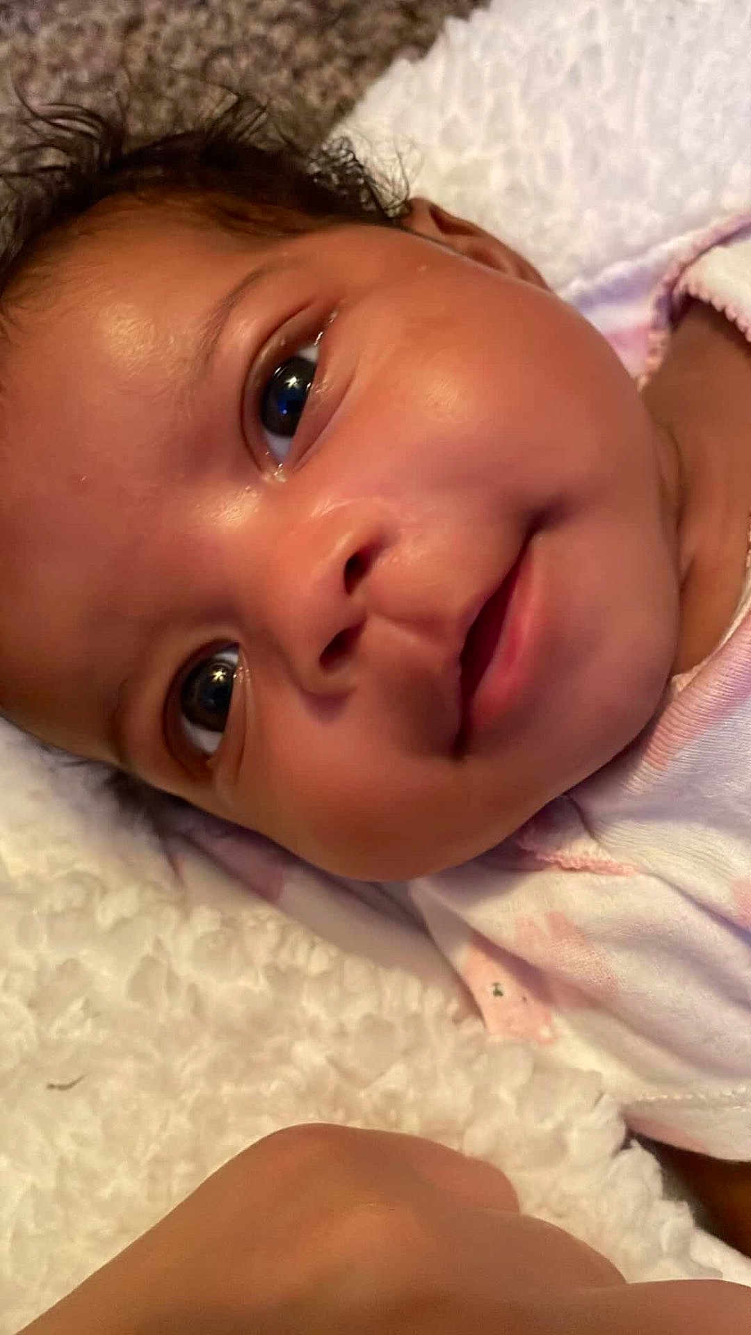 Ki'Mani joined the competition — help win amazing prizes! baby, infant, face, smile, eyes, skin, blanket, close_up, portrait, cute, child, lying_down, soft_texture, expression, newborn, human, person, indoors, head, happy