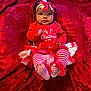 baby, infant, child, red_clothing, striped_leggings, tutu, headband, bow, blanket, plush, christmas, holiday, festive, cute, feet, portrait, indoors, celebration, holiday_outfit, smiling