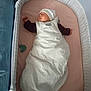 baby, sleeping, bassinet, crib, white_hat, sleep_sack, pacifier, striped, pink_mattress, infant, peaceful, indoor, child, resting, soft, cozy, newborn, clothing, bed, quiet