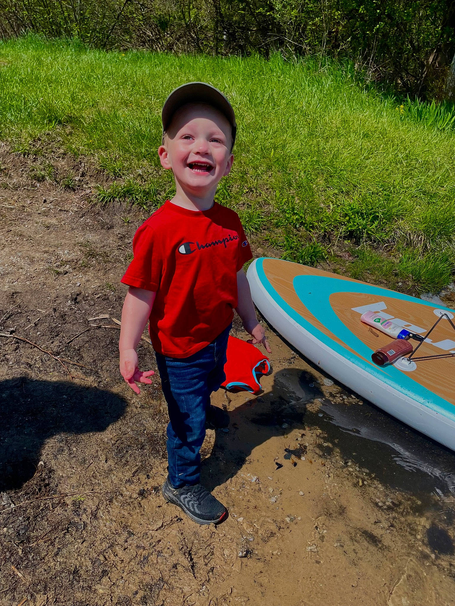 Elliot is registered to the contest to win money with this photo: asphalt, boats_and_boating_equipment_and_supplies, fun, grass, happy, headwear, joy, landscape, leisure, people_in_nature, person, personal_protective_equipment, plant, play, recreation, smile, soil, surface_water_sports, surfboard, surfing