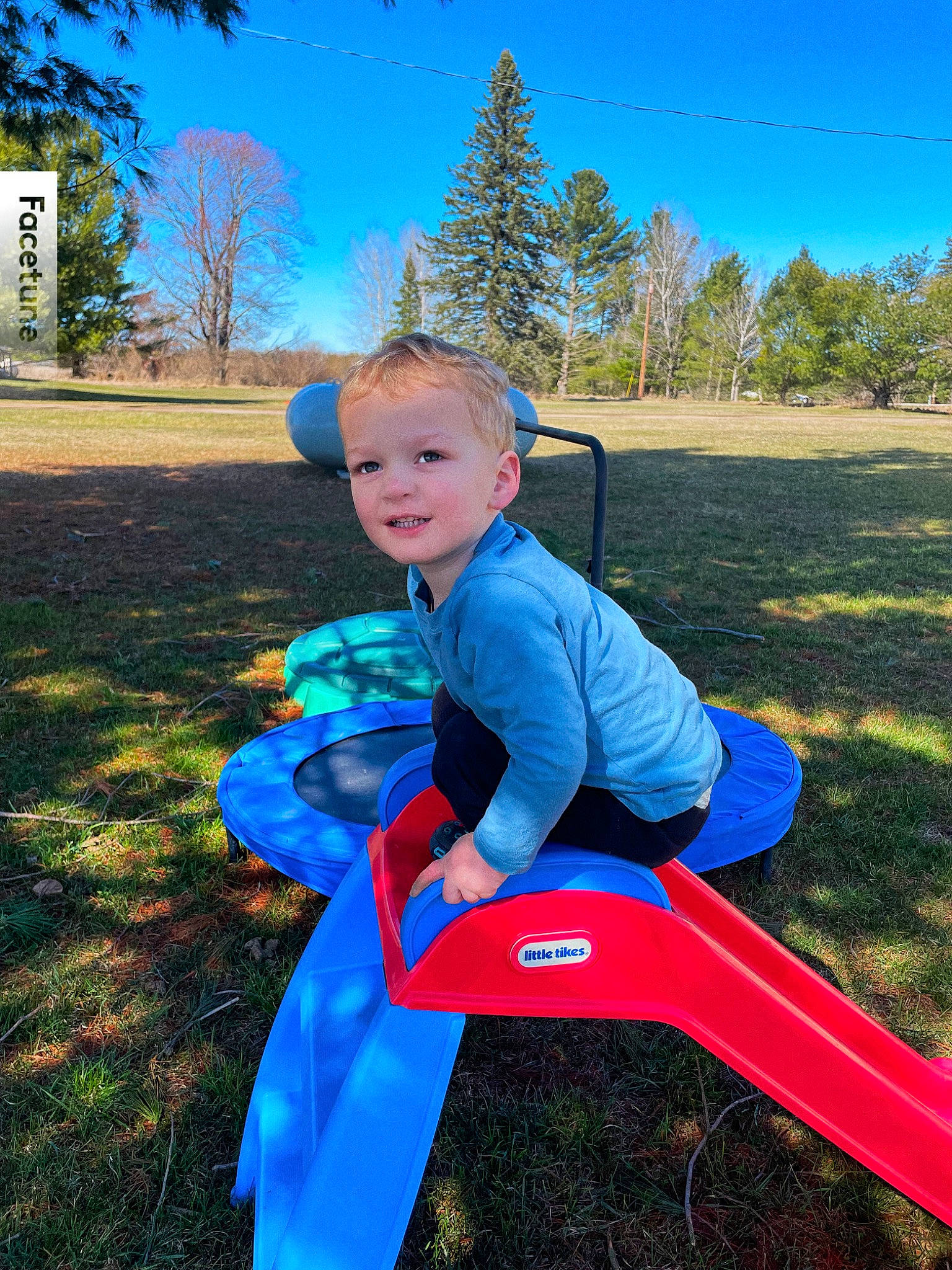 Elliot is registered to the contest to win money with this photo: baby, blue, chair, child, electric_blue, fun, grass, happy, joy, landscape, leisure, outdoor_play_equipment, people_in_nature, person, play, recreation, sitting, sky, smile, t_shirt