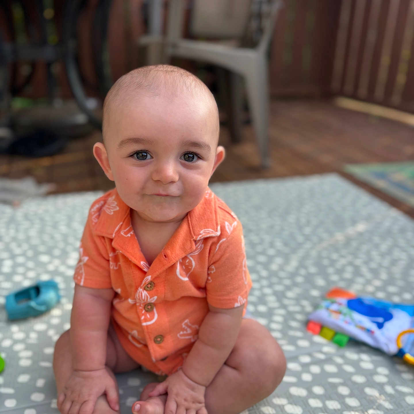 Wesley joined the competition — help win amazing prizes! baby, backyard, chair, child, curious, cute, expression, face, foot, hand, infant, orange_shirt, outdoor, playtime, polka_dot_mat, portrait, sitting, skin, toy, wooden_fence