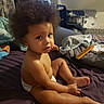 Reign is registered to the contest to win money with this photo: toddler, child, baby, diaper, curly_hair, sitting, bed, bedroom, portrait, face, eyes, looking_at_camera, indoor, home, television, comb, laundry, blanket, furniture, baby_gear