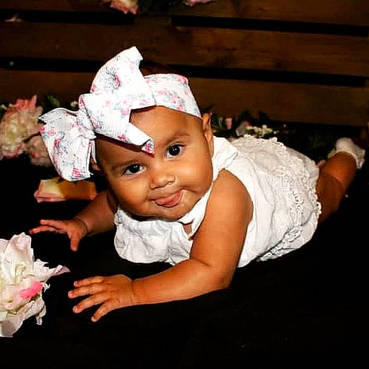 Magia is registered to the contest to win money with this photo: artificial_flower, baby, baby_toddler_clothing, bonnet, cheek, child, child_model, costume_accessory, costume_hat, cut_flowers, flash_photography, hair_accessory, headband, headgear, headpiece, headwear, person, pink, portrait_photography, toddler