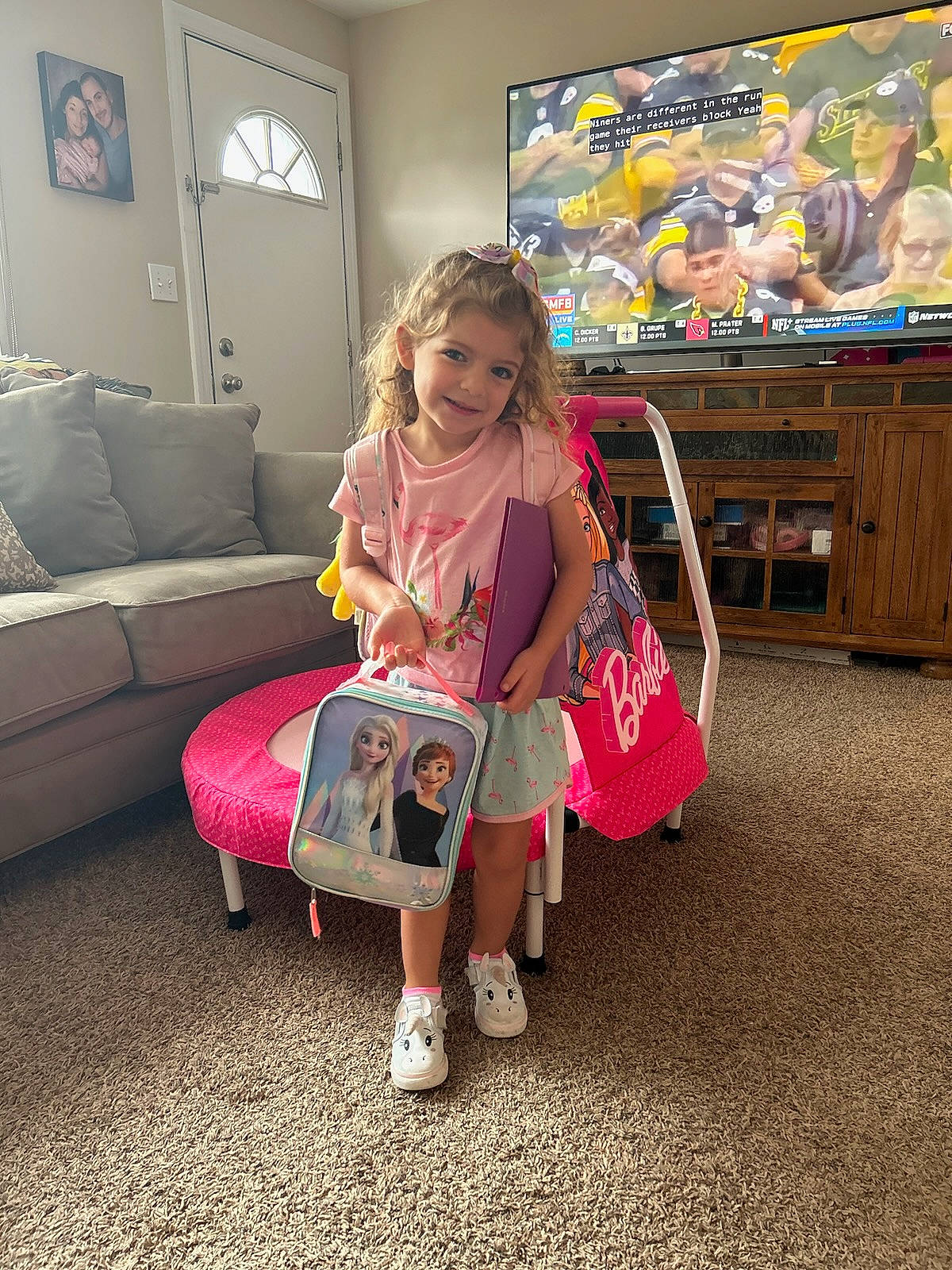 Marissa is registered to the contest to win money with this photo: art, child, comfort, couch, event, floor, flooring, fun, happy, headwear, joy, leisure, living_room, luggage_and_bags, magenta, person, picture_frame, pink, sandal, sitting