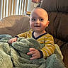 Rowan is registered to the contest to win money with this photo: baby, child, blanket, striped_clothing, smile, blue_eyes, indoor, chair, cozy, soft_texture, curtains, sunlight, happy, portrait, infant, person, home, cute, warm, relaxed