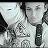 black_and_white, casual, cat, closeup, comfort, cozy, earring, expression, face, feline, home, indoor, lying_down, person, pet, portrait, relaxed, remote_control, sweatshirt, whiskers