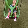toddler, child, swing, playground, green_swing, adaptive_swing, grass, outdoor, fence, parked_cars, shoes, pink_socks, denim_overalls, shorts, hair_tie, daylight, person, seat, leisure, play