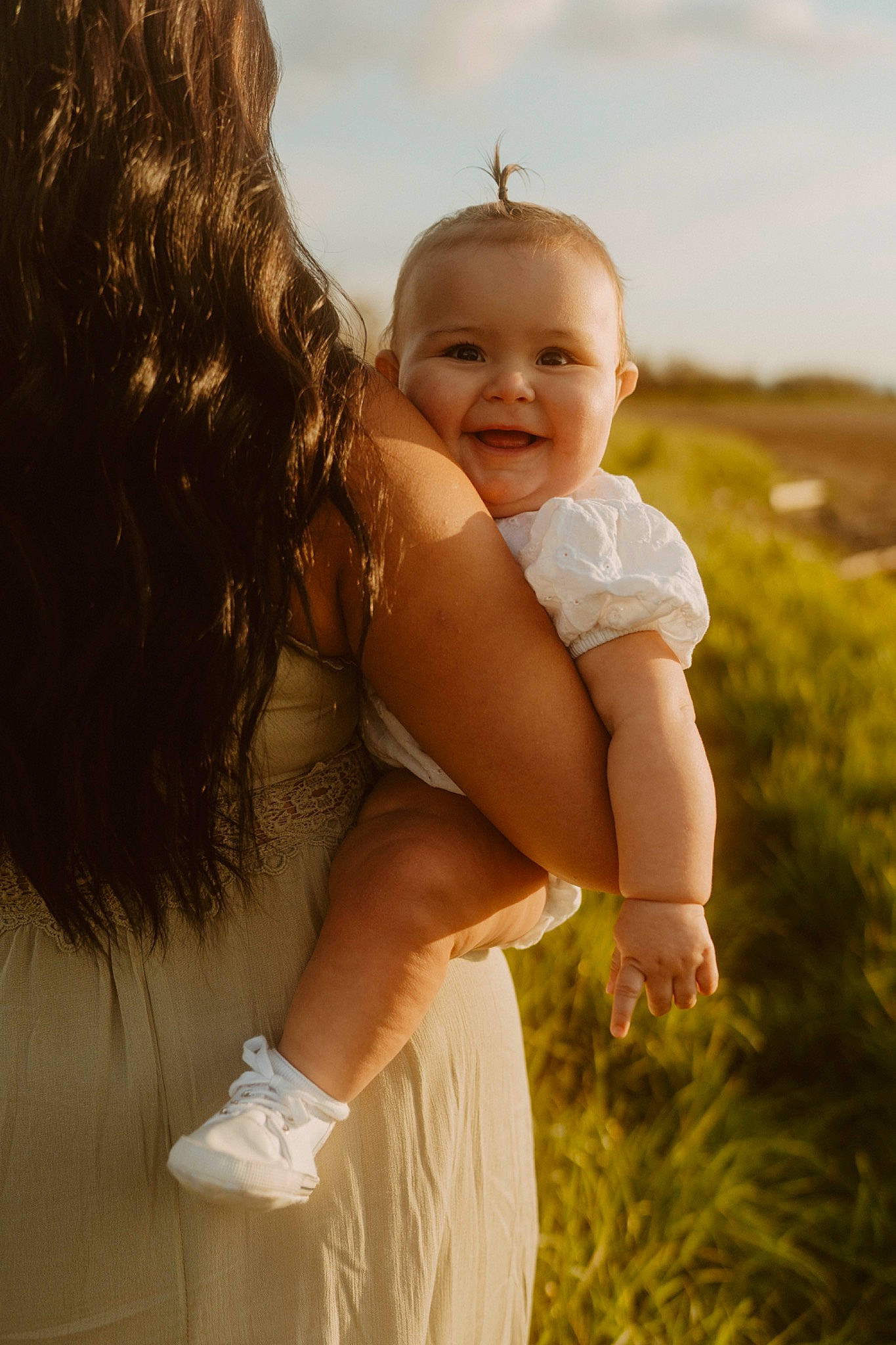 Lyla is registered to the contest to win money with this photo: baby, beauty, dress, flash_photography, fun, gesture, grass, hand, happy, human, human_body, iris, joy, people_in_nature, person, plant, shoulder, skin, sky, smile