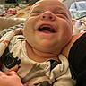 Sawyer joined the competition — help win amazing prizes! baby, infant, child, smiling, laughing, face, portrait, close_up, indoor, home, held, adult, hands, clothing, onesie, patterned_clothing, blanket, bed, cozy, happy