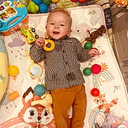 Louis a rejoint le concours — aidez-le/la à gagner de superbes lots ! baby, infant, smile, toy, play_mat, balls, playpen, shirt, pants, giraffe_toy, toy_car, rattle, plush, rainbow, fox_illustration, happy, lying_down, indoors, colorful, cheerful