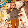 baby, infant, smile, toy, play_mat, balls, playpen, shirt, pants, giraffe_toy, toy_car, rattle, plush, rainbow, fox_illustration, happy, lying_down, indoors, colorful, cheerful