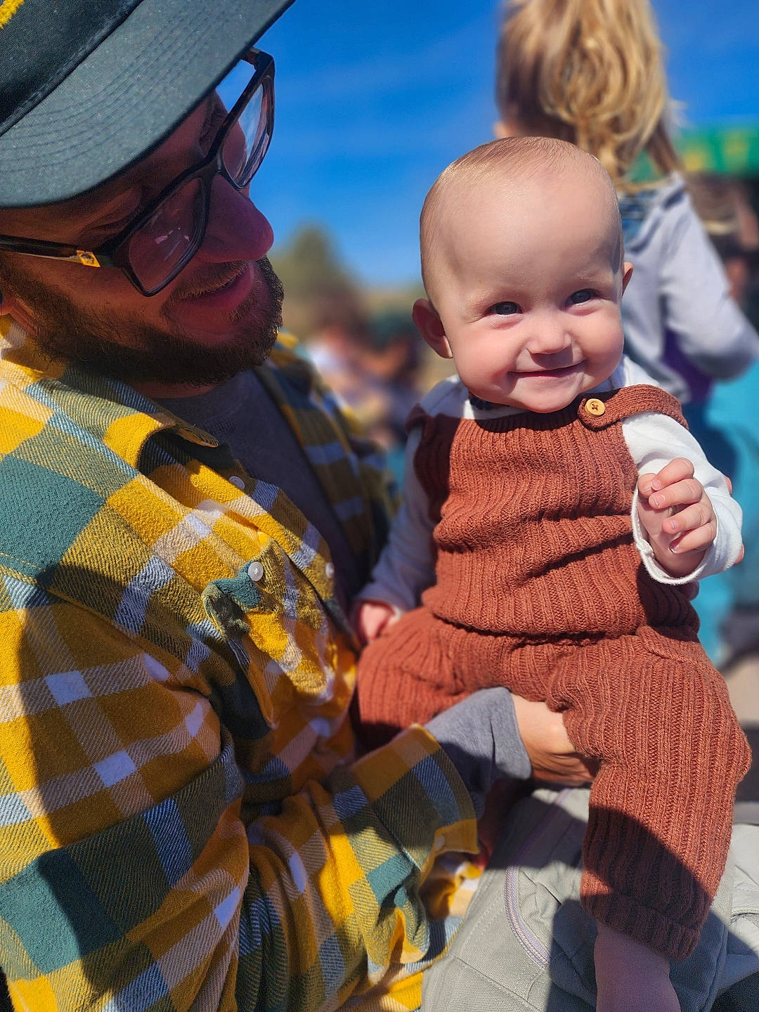 Tilly is registered to the contest to win money with this photo: baby, cap, child, event, eyewear, fun, gesture, happy, hat, interaction, joy, pattern, person, plaid, skin, sky, smile, sun_hat, t_shirt, tartan