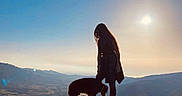 Orsu participe au concours pour gagner de l'argent avec cette photo : silhouette, person, dog, rock, mountain, sunset, sky, outdoor, nature, landscape, hill, pet, animal, scenic, evening, travel, adventure, shadow, sun, walking
