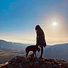 silhouette, person, dog, rock, mountain, sunset, sky, outdoor, nature, landscape, hill, pet, animal, scenic, evening, travel, adventure, shadow, sun, walking