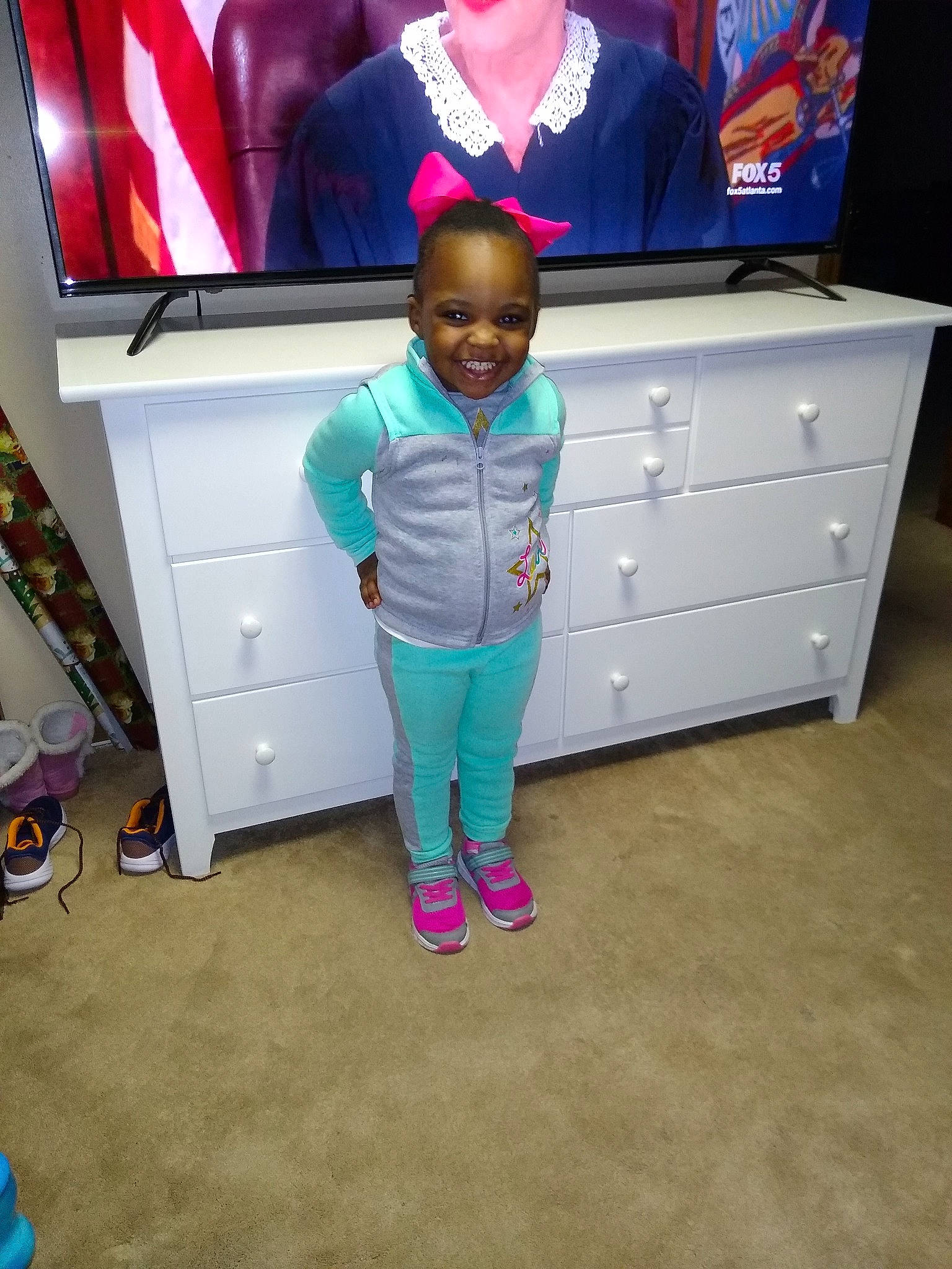 Tori is registered to the contest to win money with this photo: child, electronic_device, footwear, fun, furniture, joy, person, pink, play, room, shoe, t_shirt, technology, toddler