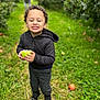 adult, apple, boy, child, clothing, coat, face, food, fruit, grass, head, jacket, male, man, pants, person, photography, plant, portrait, produce