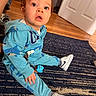 toddler, child, indoor, blue_hoodie, shark_pattern, sneakers, carpet, wooden_floor, door, curious, expression, sitting, young_child, playful, pacifier, clothing, floor, person, footwear, casual