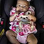 baby, infant, car_seat, pink_clothing, headband, teddy_bear, child, cute, adorable, seatbelt, sitting, looking_at_camera, indoors, soft_lighting, young_child, clothing, person, baby_girl, portrait, closeup