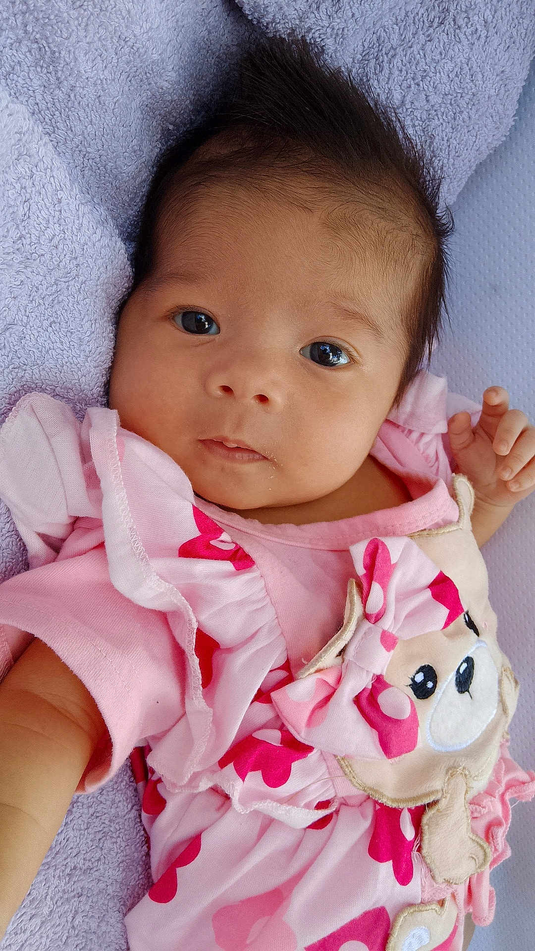 Siana participe au concours pour gagner de l'argent avec cette photo : baby, infant, face, pink_clothing, towel, cute, portrait, child, looking_at_camera, soft_texture, animal_patch, ruffles, hand, skin, hair, eyes, newborn, lying_down, indoors, closeup