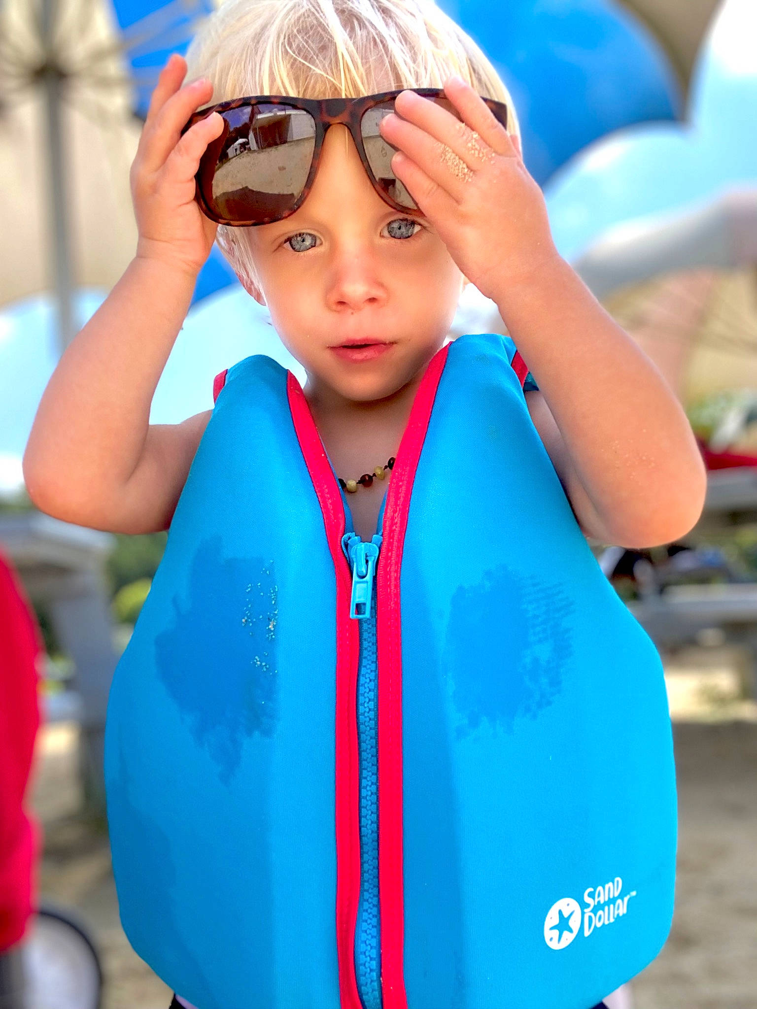 Jameson is registered to the contest to win money with this photo: aqua, azure, blue, cool, electric_blue, eyewear, finger, fun, gesture, goggles, hairstyle, happy, headwear, leisure, person, personal_protective_equipment, recreation, sleeve, sunglasses, toddler