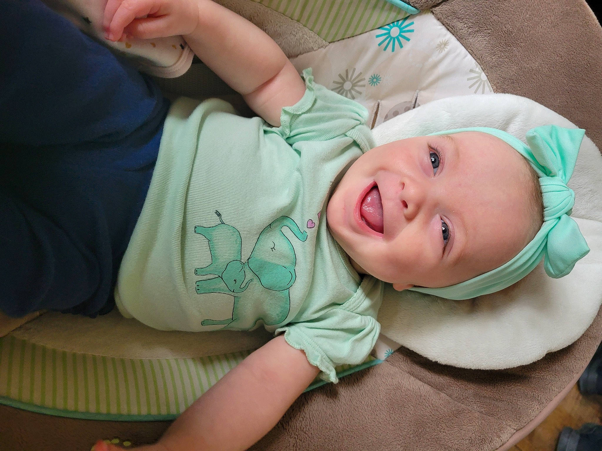 Rory is registered to the contest to win money with this photo: arm, baby, baby_products, baby_toddler_clothing, cheek, child, comfort, eye, fashion_accessory, finger, grass, happy, hat, laugh, pattern, person, sitting, skin, sleeve, smile