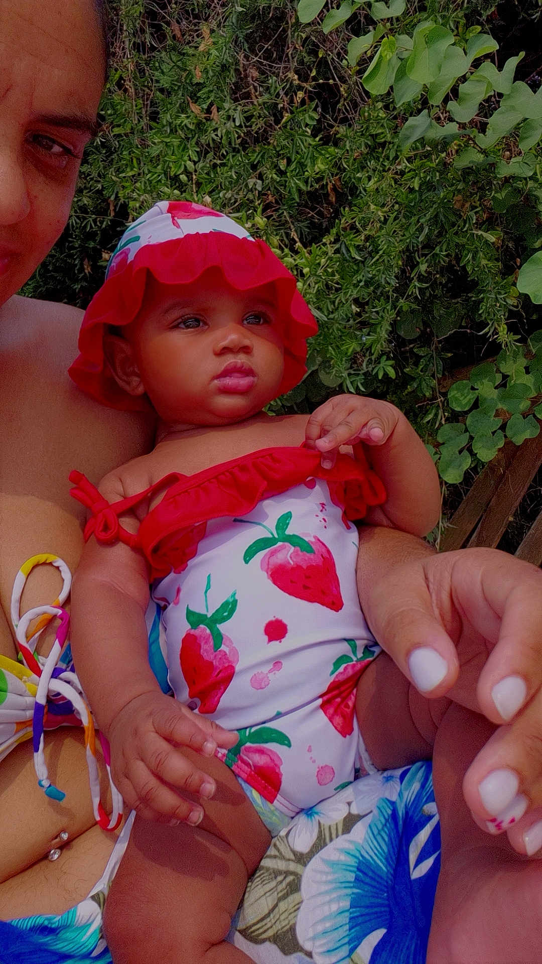 Shayna participe au concours pour gagner de l'argent avec cette photo : adult, baby, child, cute, daylight, greenery, hand, hat, holding, leaf, nature, outdoor, person, portrait, skin, smile, strawberry_pattern, summer, swimsuit, tropical