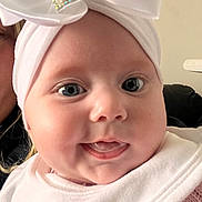 Aurora joined the competition — help win amazing prizes! baby, close_up, face, headband, bow, smile, tongue, infant, cute, child, indoor, person, apparel, white, pink, skin, eyelashes, cheeks, expression, portrait