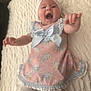 Aurora is registered to the contest to win money with this photo: baby, infant, smiling, dress, headband, bow, white_socks, lying_down, blanket, happy, cute, child, portrait, indoors, person, young, celebration, fashion, accessory, home