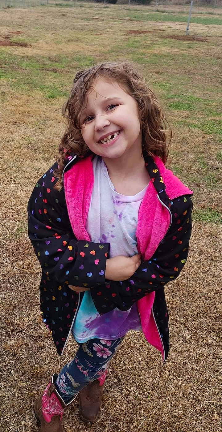 Raven is registered to the contest to win money with this photo: baby_toddler_clothing, blond, child, eye, facial_expression, fun, grass, grassland, hair, happy, head, joy, long_hair, magenta, outerwear, pattern, people_in_nature, person, pink, sleeve